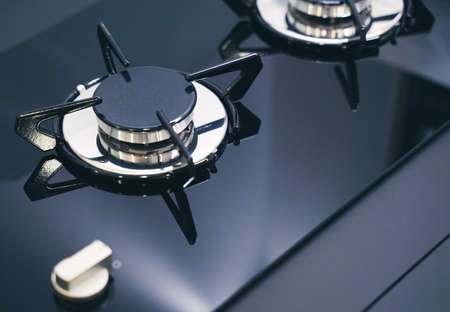 closeup perspective view of modern expensive black gas stove for camper RV with glass and metal finish on dialsの写真素材