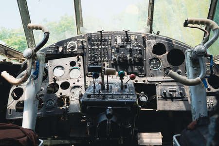 front view closeup of vintage world war two airplane cockpit interior with old instrument panel and flight controlsの写真素材