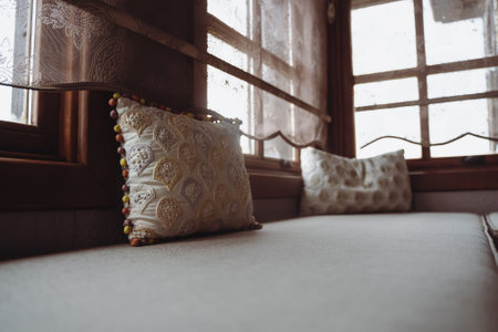 front view of divan with several pillows in front of windowの写真素材