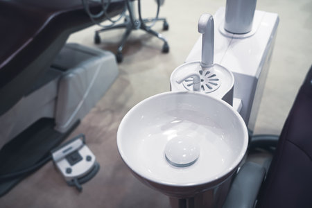 closeup top view of clear dental white ceramic spit sink near chair in dentist officeの写真素材
