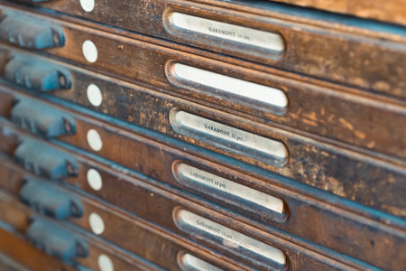 A wooden drawer containing vintage metal printing type showing detailed craftsmanshipの写真素材