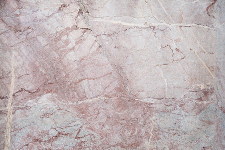 A detailed closeup of beige marble texture with visible cracks and veins creating an organic patternの写真素材