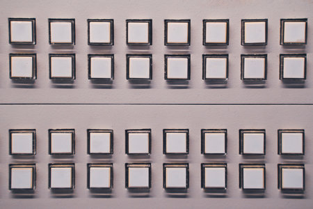 A closeup of multiple white buttons arranged in symmetrical rows on a control panel for a clean and modern lookの写真素材