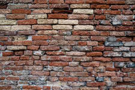 A detailed view of a rustic red brick wall showcasing textured and weathered surfaces