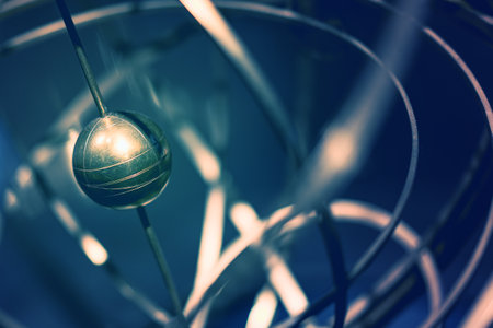 Artistic view of an armillary sphere with a brass globe representing celestial bodies in a dark settingの写真素材