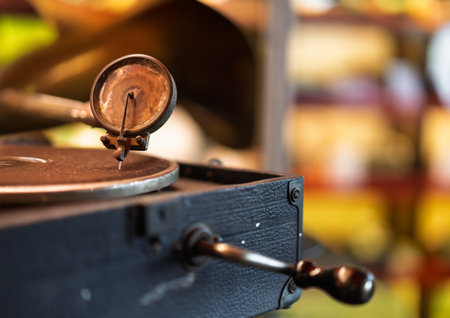 A detailed closeup of a vintage phonograph needle and arm resting on a record player with blurred backgroundの写真素材