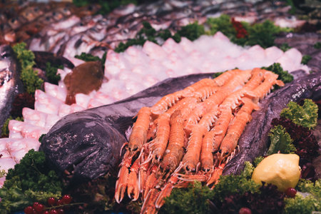 Langoustines and fresh seafood beautifully displayed on ice in a vibrant market settingの写真素材