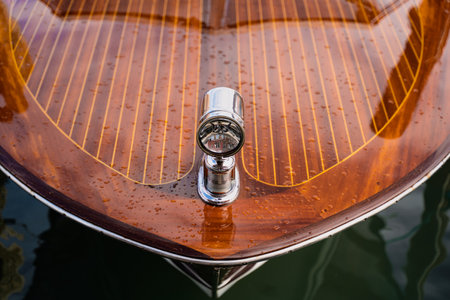 A closeup view of a glossy wooden boat deck featuring a chrome light fixtureの写真素材