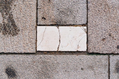 A closeup of a marble and stone pavement showcasing contrasting textures and tonesの写真素材
