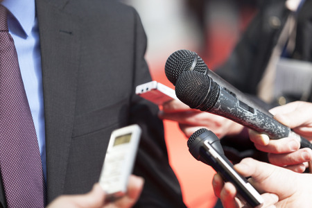 A journalist is making a interview with a microphone