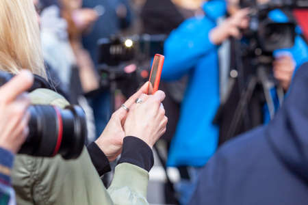 Press or news conference, mobile journalist filming media event with a smartphoneの写真素材
