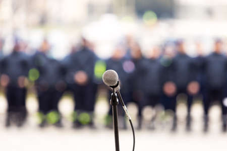 Focus on microphone, blurred crowd of people in the background