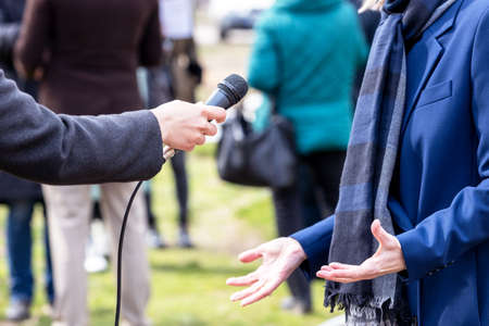 Journalist making media interview with elegant unrecognizable female personの写真素材