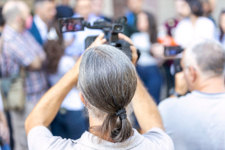 Camera operator filming media event or news conferenceの写真素材