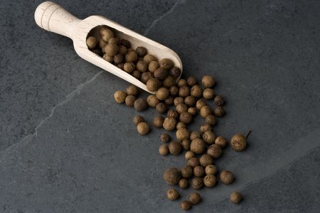 Allspice berries in a wooden scoop.の写真素材