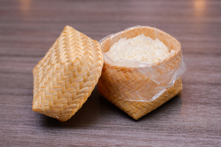 Streamed sticky rice in wicker basket on wood tableの写真素材