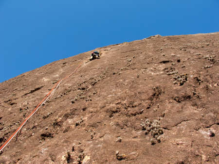 Rock climber climbing a sloping rock wall in Brazil
