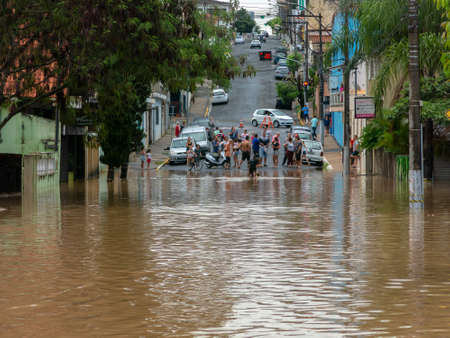 CAPIVARI, BRAZIL - JAN 06, 2019 - People crossing flooded streets - Capivari river overflow - Sao Paulo - Brazilのeditorial素材