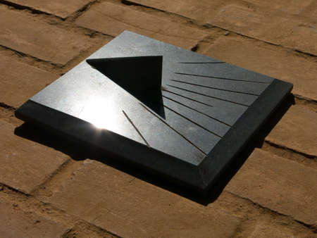 Granite Sundial - sun clock on orange brick floor
