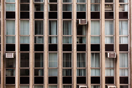 Modern glass windows in concrete building facade - urban modern architecture