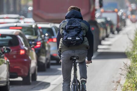 Cyclist passing traffic jamの写真素材