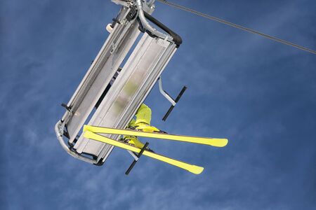 Skier with yellow ski on chair liftの写真素材