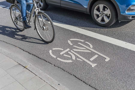 car beneath cyclist on bike lane