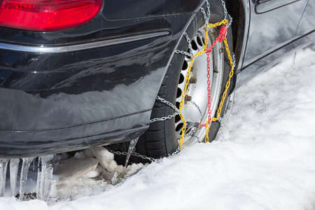 snow chains on rear tire of black car