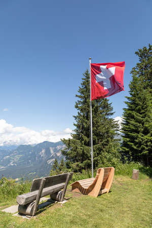 viewpoint with wooden benches on chur's local mountainの写真素材
