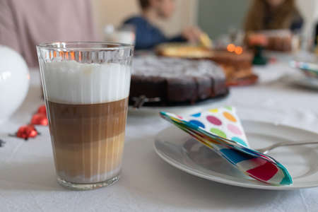 coffee with milk foam and cake on the tableの写真素材