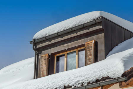 thick layer of snow on dormer windowの写真素材