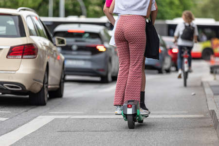 young women ride in pairs on electric scooterの写真素材