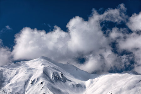 clouds over snowy mountain range