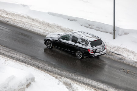 Black station wagon on a winter roadの写真素材
