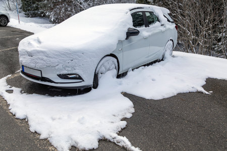 white station wagon partially covered with snowの写真素材