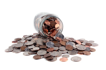 U.S. coins spilled from a jar on white.