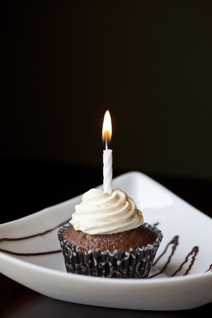 Chocolate Cupcake with a Burning Birthday Candleの写真素材