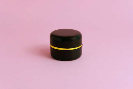 Front top view - black bottle makeup cream mock-up with pink background. Image photoの写真素材