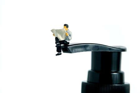 Health conceptual photography â miniature people reading above hand sanitizer bottle â read how to apply disinfectant to protect from virus. Image Photoの写真素材