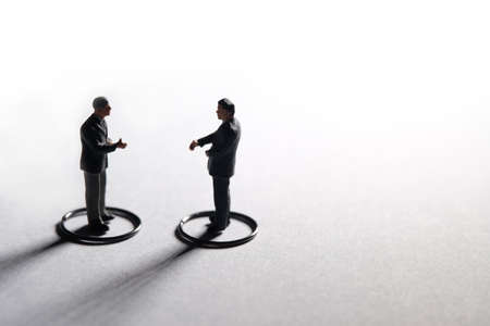 Two businessmen make partnership agreement with maintain physical distance. Miniature people...