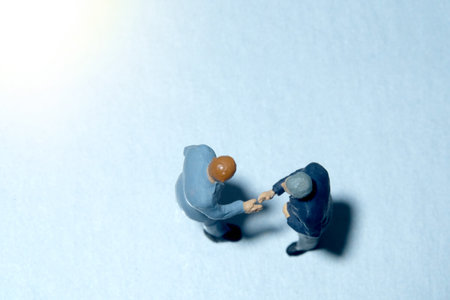 Top view of two businessmen make an handshake partnership agreement. Miniature people figure conceptual photographyの写真素材