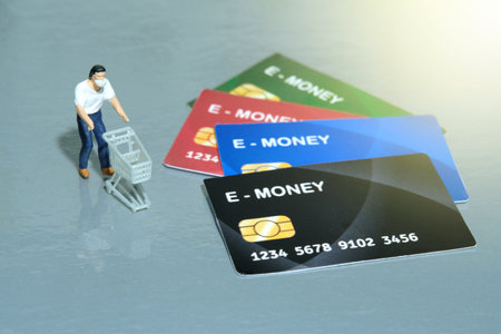 Contact-less payment. A men going shop and pay using electronic money (e-money). Miniature people figurines toys conceptual photography.の写真素材