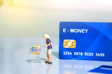Contact-less payment. Women going shop and pay using electronic money (e-money). Miniature people figurines toys conceptual photography.の写真素材