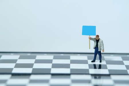 Activist demonstrator standing chess board with empty blank text banner - Miniature people toys photographyの写真素材