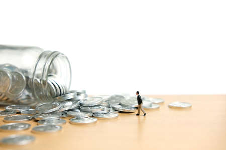 A businessmen walking on coin stack - Financial saving. Miniature people figure conceptual photography.の写真素材