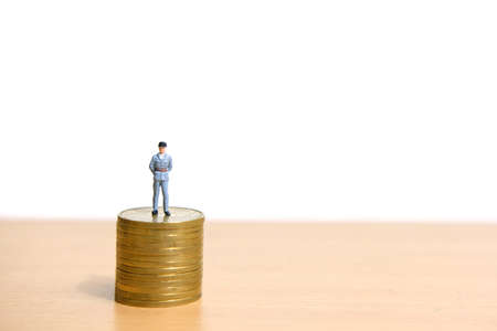 Policeman standing above coin stack to protect money. Miniature people figure conceptual photography.の写真素材