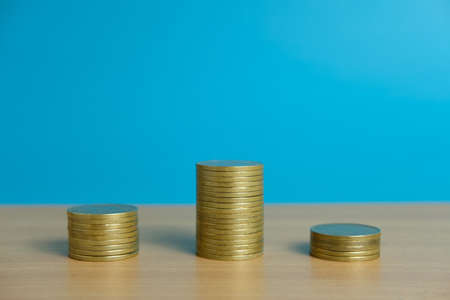 Stack of golden money coin on a wooden tableの写真素材