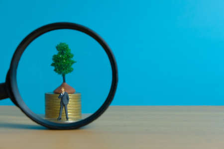 Miniature business concept - thinking businessman looking for financial solutionの写真素材