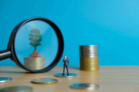 Miniature business concept - thinking businessman looking for financial solutionの写真素材