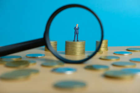 Miniature business concept - thinking businessman looking for financial solutionの写真素材